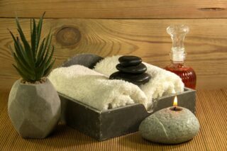 massage towels and oil with a candle on a table